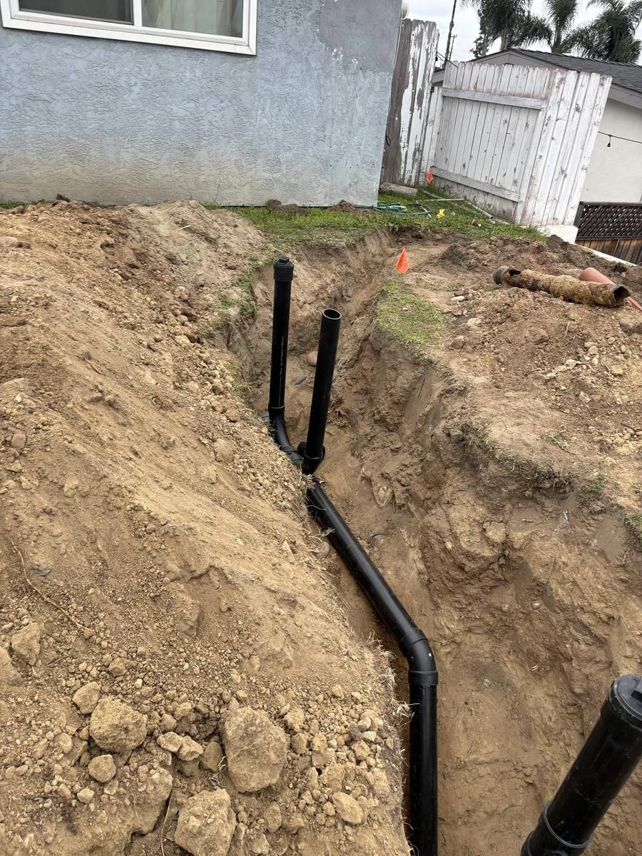 New ABS sewer lateral with two code-required cleanout risers; failed clay pipe removed
