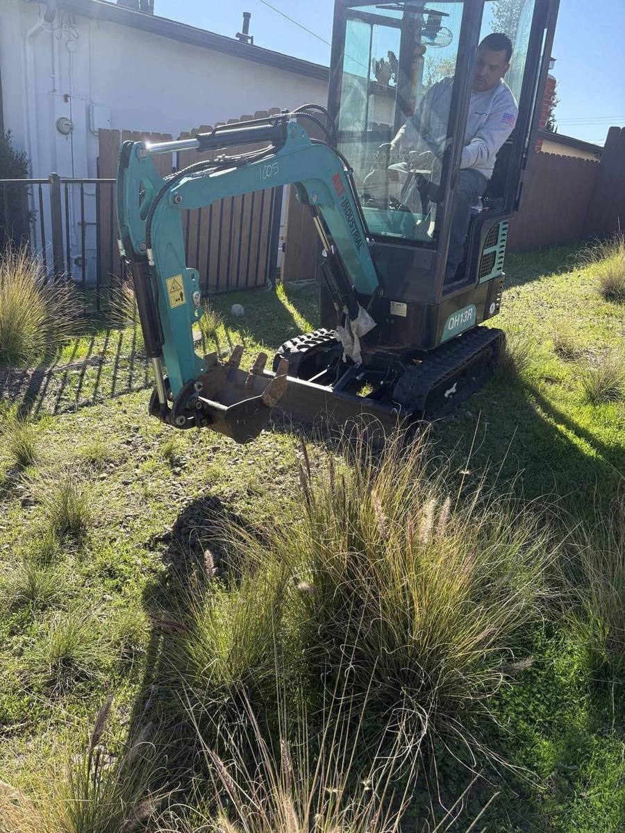 Viper compact excavator digging a residential sewer lateral in a San Diego yard