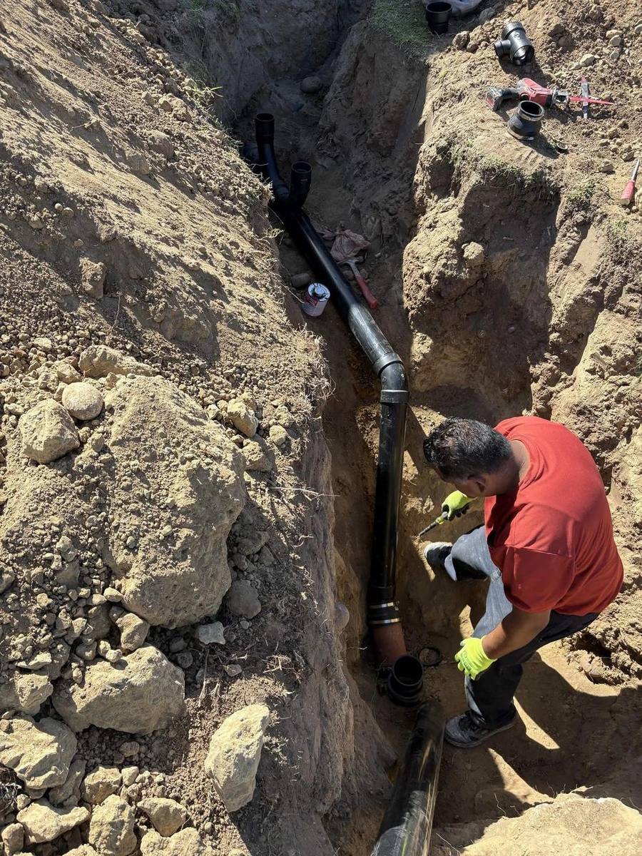Viper technician setting new ABS sewer pipe in a deep trench